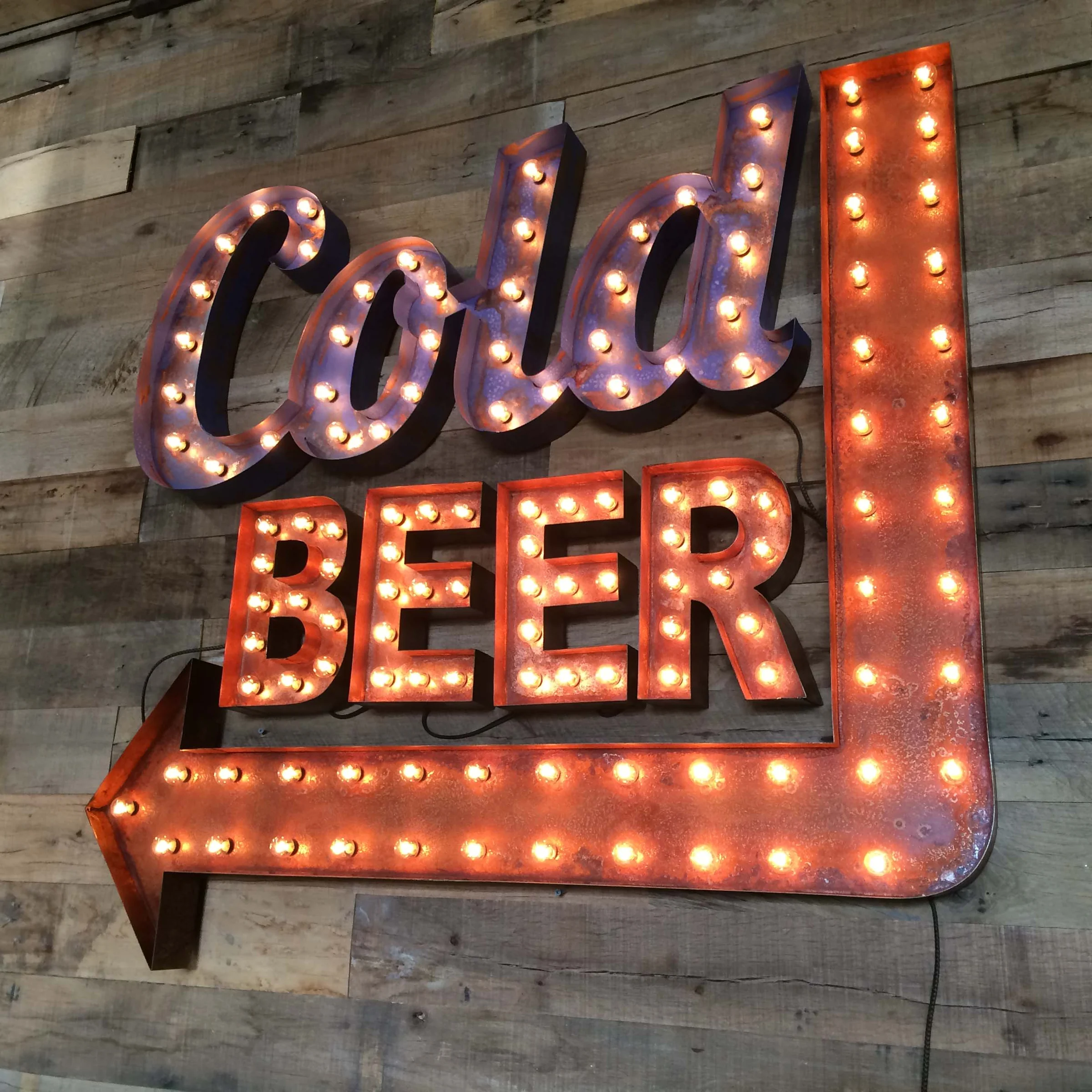 Finished illuminated Cold Beer wall sign with a left-pointing arrow