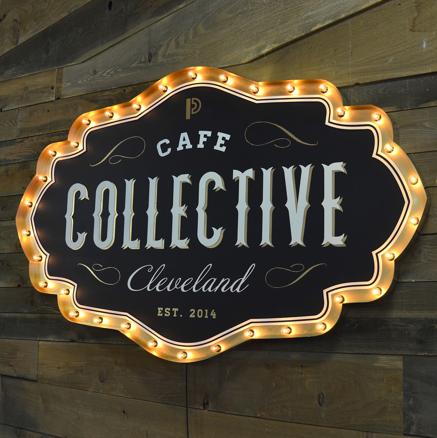 Cafe Collective Cleveland shaped logo sign outlined with lit marquee bulbs