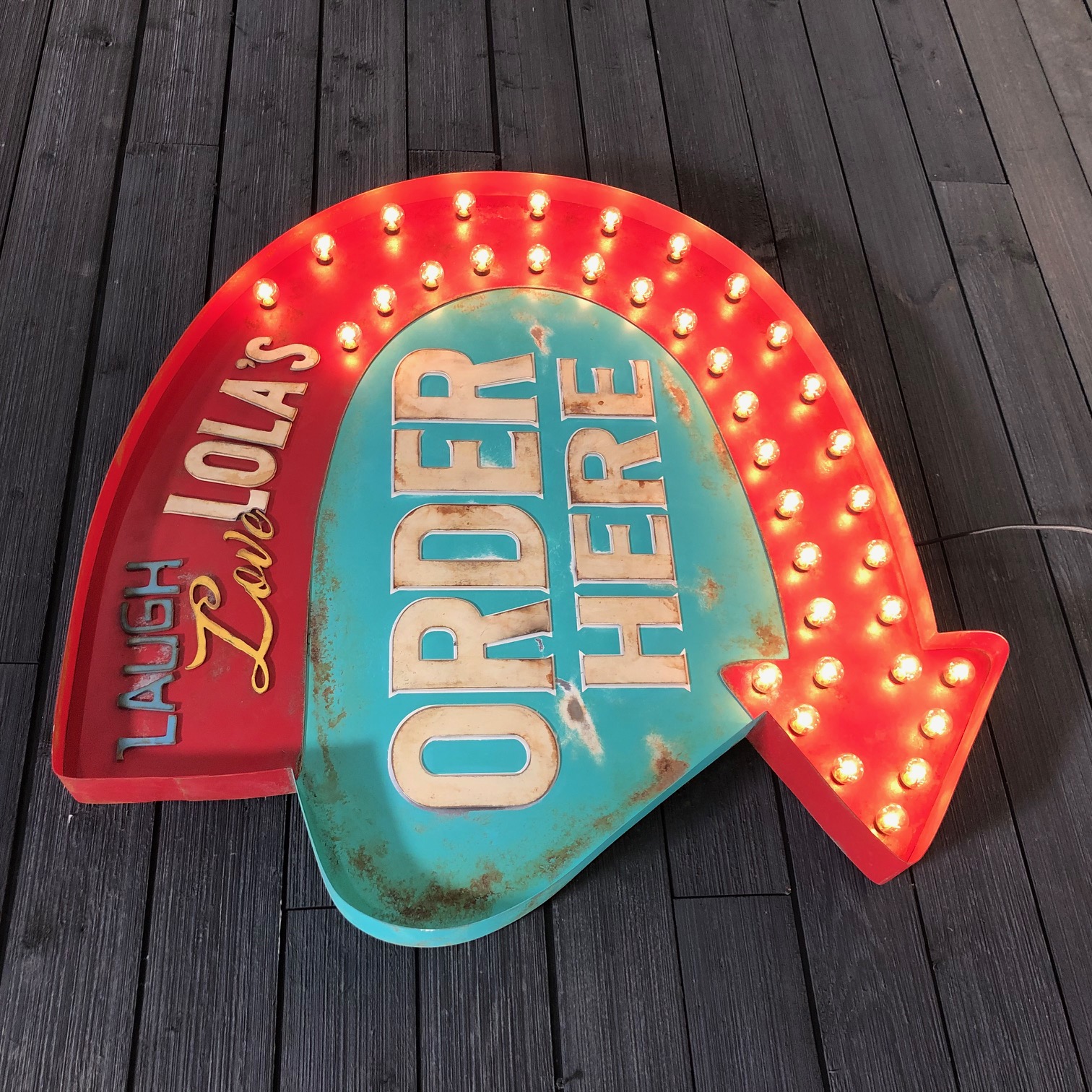 Lola's arrow-shaped ORDER HERE sign with lit bulbs and dimensional lettering