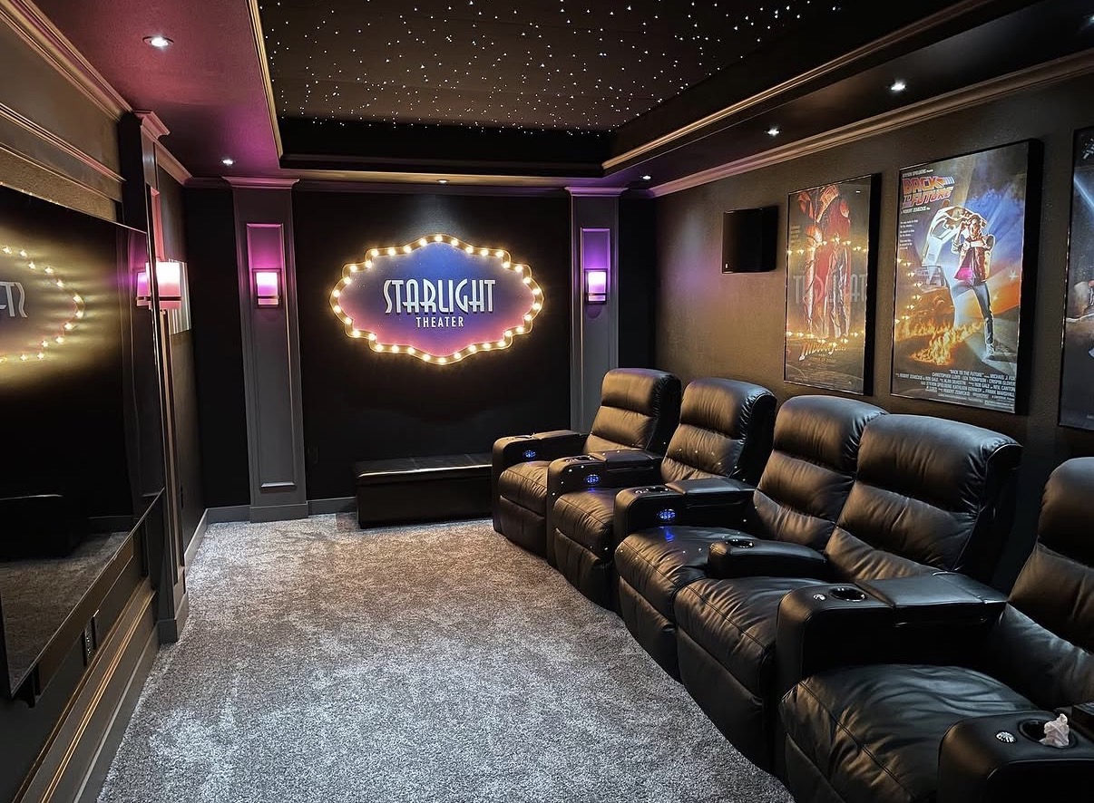 Starlight Theater bulb-lit logo sign mounted in a home theater room