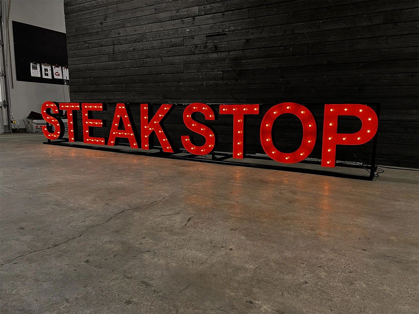 Finished red illuminated STEAKSTOP letters standing in the shop