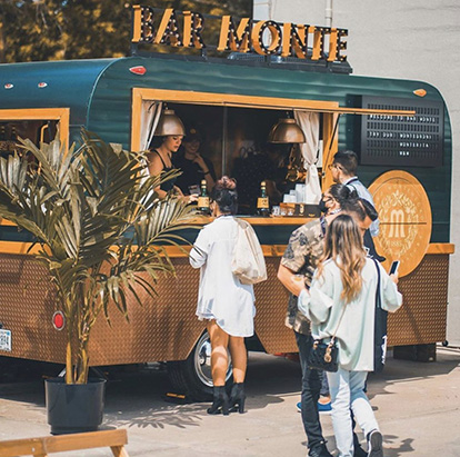 Bar Monte food truck with custom illuminated marquee sign on the roof attracting customers at an outdoor market