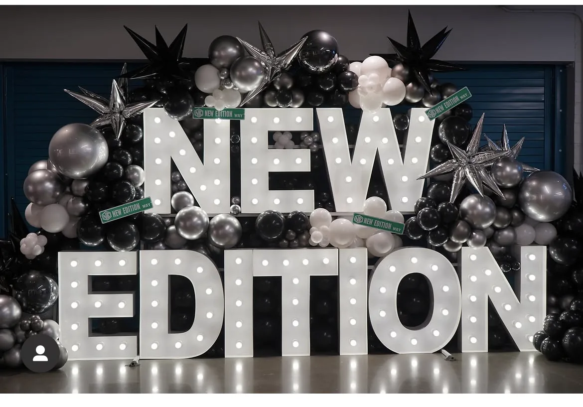 NEW EDITION marquee lights with a black and silver balloon backdrop by C&D Marquees