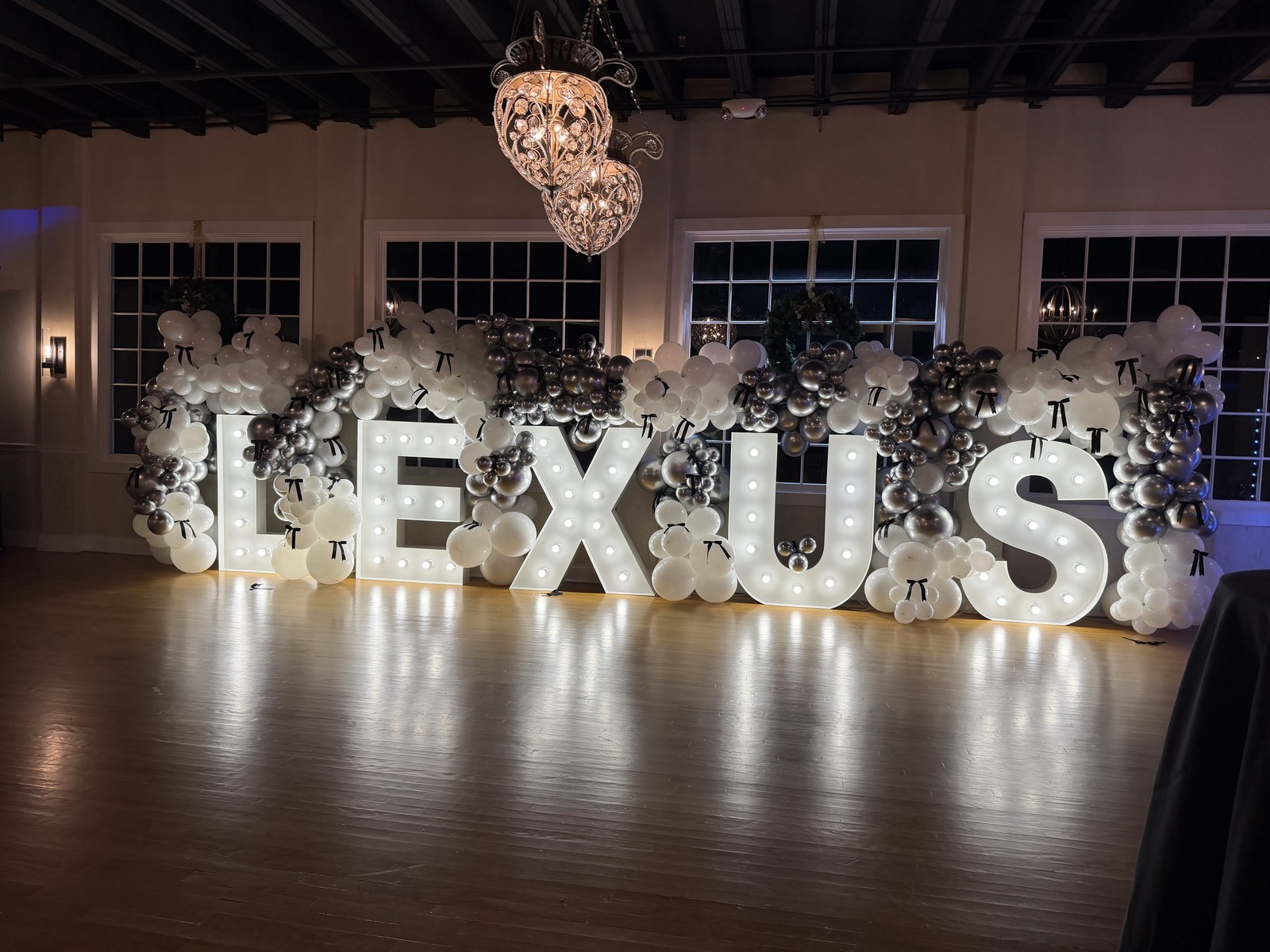 LEXUS illuminated marquee letters styled with a silver and white balloon garland at a Lexus holiday party